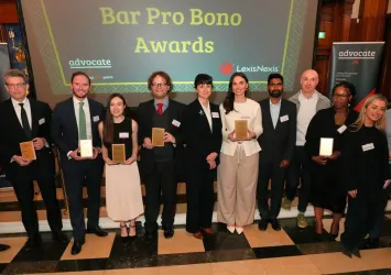 Award recipients holding plaques at 2026 Bar Pro Bono Awards ceremony in formal venue